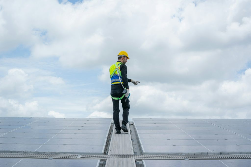 Engineer man or worker checking the operation of the system solar panels or solar cells on roof.